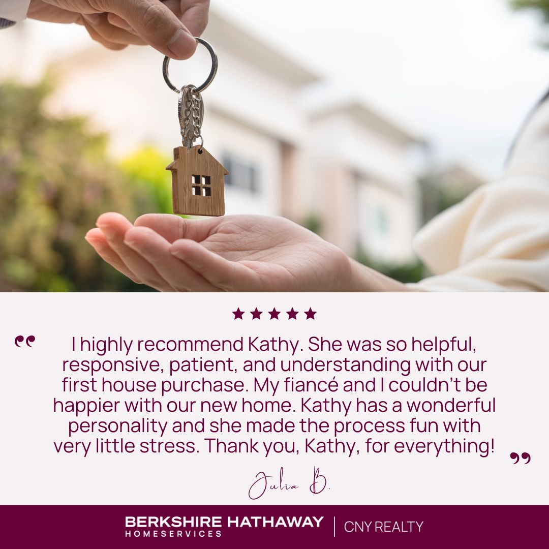 A person handing another person a set of keys on a keychain shaped like a house. 