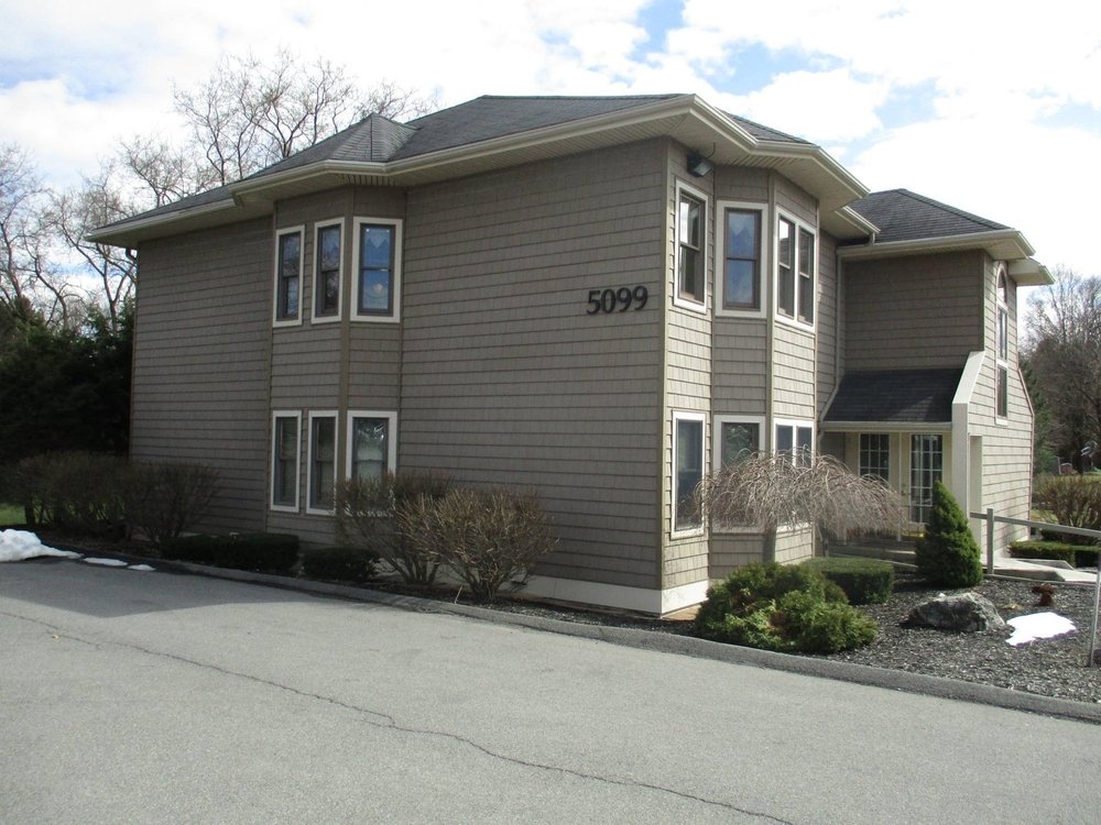 Exterior of a two-story tan office building with landscaping