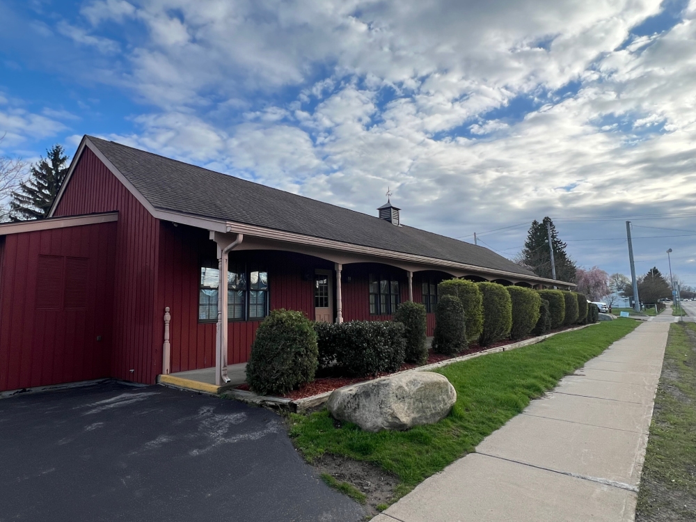 Exterior of a red building with a sidewalk in front